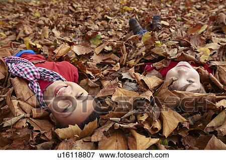 Stock Photo - Children playing in autumn leaves. Fotosearch