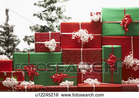Stock Photo - Christmas gifts by tree. Fotosearch