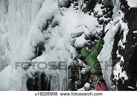 Climber with picks descending snowy hill View Large Photo Image Stock Photo - Climber with picks descending snowy hill. Fotosearch