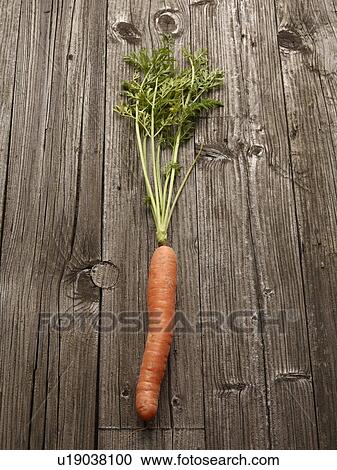 Stock Image - Close up of carrot on wooden table. Fotosearch