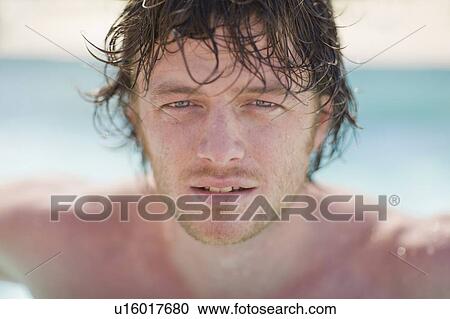 Stock Image - Close up of mans face in pool. Fotosearch