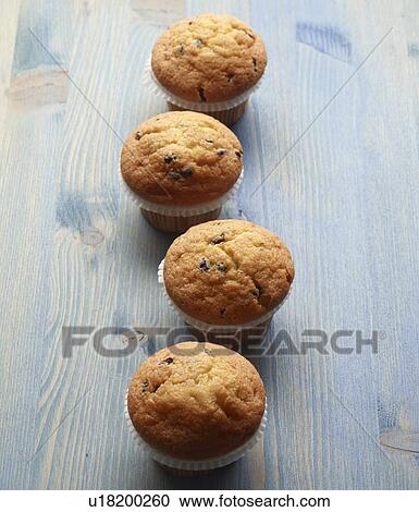 Stock Image - Close up of muffins on wooden table. Fotosearch