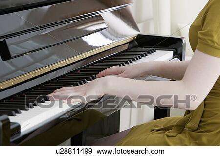 Stock Photo - Close up of teenage girl playing piano. Fotosearch