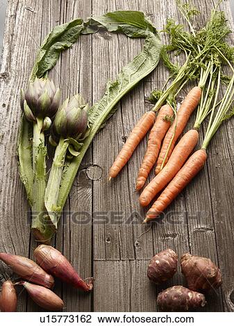 Stock Image - Close up of vegetables on wooden table. Fotosearch
