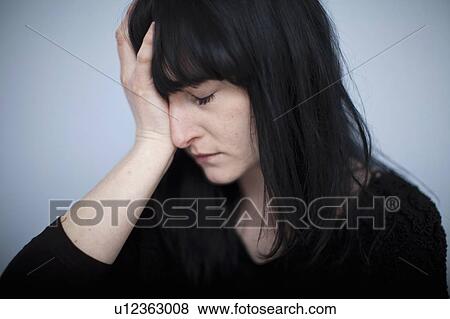 Stock Photo - Close up of woman clutching her head. Fotosearch