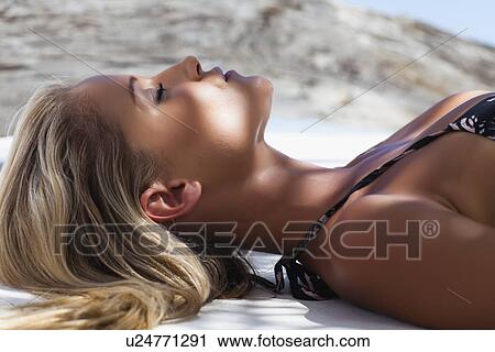 Close up of woman laying on towel View Large Photo Image Stock Image - Close up of woman laying on towel. Fotosearch