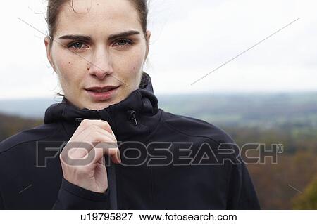 Stock Photo - Close up of woman zipping up coat. Fotosearch