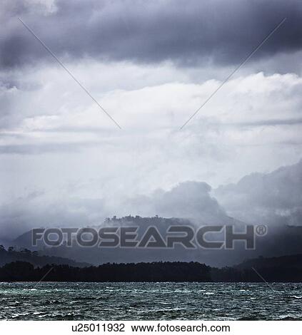 Clouds over rocky lake View Large Photo Image Stock Image - Clouds over rocky lake. Fotosearch