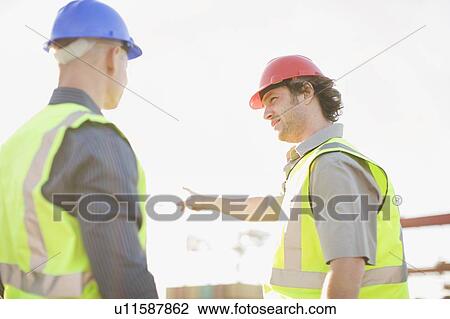 Construction workers talking on site View Large Photo Image Stock Image - Construction workers talking on site. Fotosearch