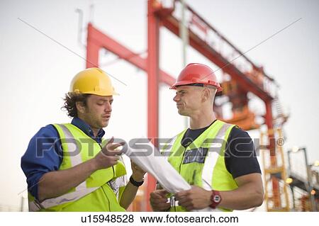 Construction workers talking on site View Large Photo Image Stock Photo - Construction workers talking on site. Fotosearch