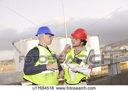 Construction workers talking on site View Large Photo Image Stock Photo - Construction workers talking on site. Fotosearch