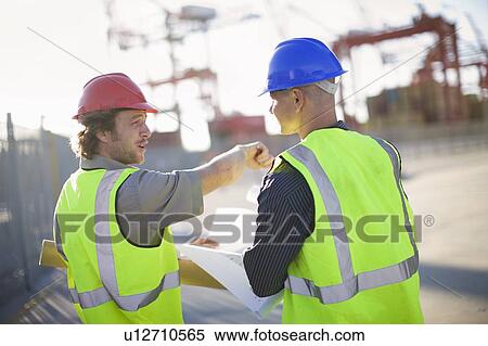 Construction workers talking on site View Large Photo Image Stock Photography - Construction workers talking on site. Fotosearch