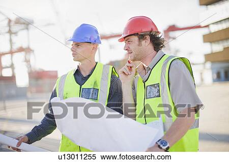 Construction workers talking on site View Large Photo Image Stock Photography - Construction workers talking on site. Fotosearch