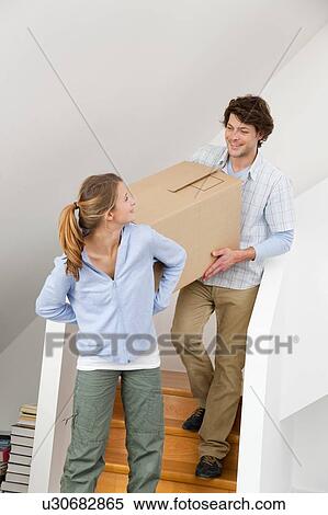 Stock Photography - Couple carrying cardboard box. Fotosearch