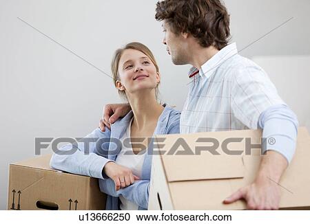 Couple carrying cardboard boxes View Large Photo Image Stock Image - Couple carrying cardboard boxes. Fotosearch
