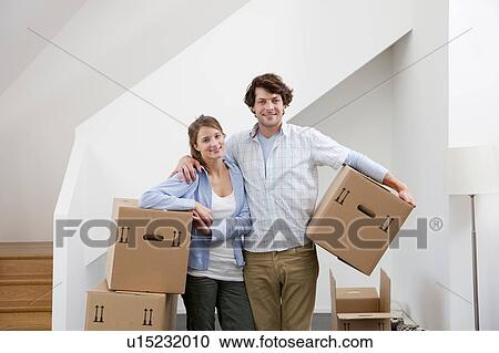 Stock Image - Couple carrying cardboard boxes. Fotosearch