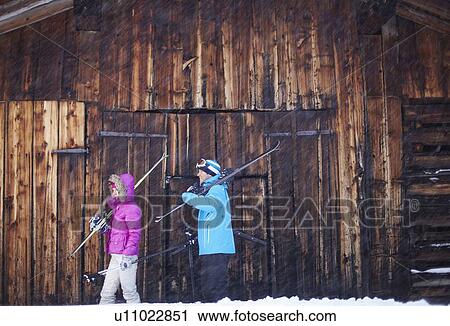 Couple carrying skis and poles in snow View Large Photo Image Stock Image - Couple carrying skis and poles in snow. Fotosearch