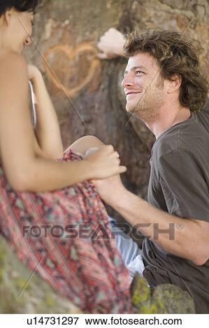 Couple carving heart in tree View Large Photo Image Stock Photo - Couple carving heart in tree. Fotosearch