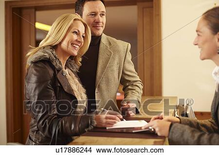 Couple checking in to hotel View Large Photo Image Picture - Couple checking in to hotel. Fotosearch