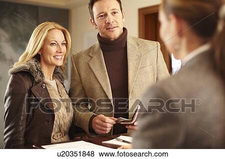 Stock Photo - Couple checking in to hotel. Fotosearch