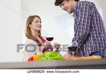 Couple cooking together in kitchen View Large Photo Image Stock Photo - Couple cooking together in kitchen. Fotosearch