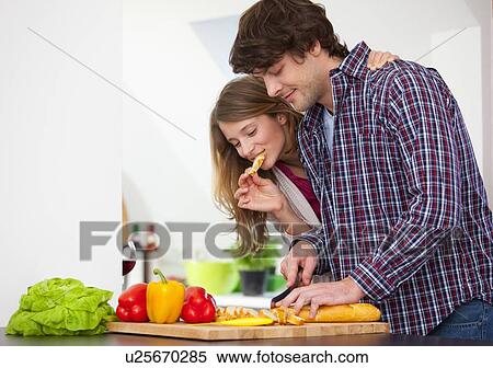 Couple cooking together in kitchen View Large Photo Image Stock Photography - Couple cooking together in kitchen. Fotosearch