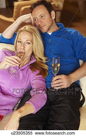 Stock Photography - Couple having champagne on sofa. Fotosearch