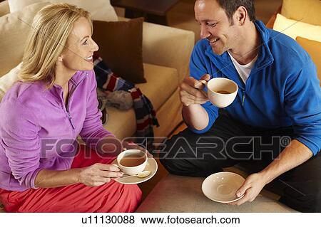 Couple having cup of coffee together View Large Photo Image Stock Photo - Couple having cup of coffee together. Fotosearch