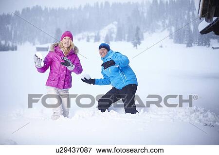 Couple having snowball fight outdoors View Large Photo Image Stock Photo - Couple having snowball fight outdoors. Fotosearch