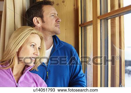 Couple hugging at window View Large Photo Image Stock Image - Couple hugging at window. Fotosearch