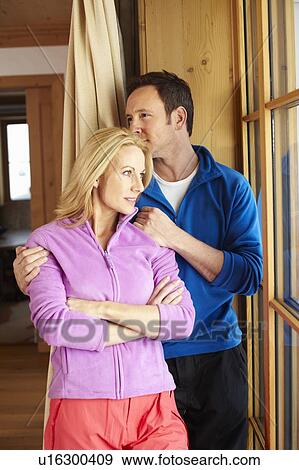 Couple hugging at window View Large Photo Image Stock Photo - Couple hugging at window. Fotosearch