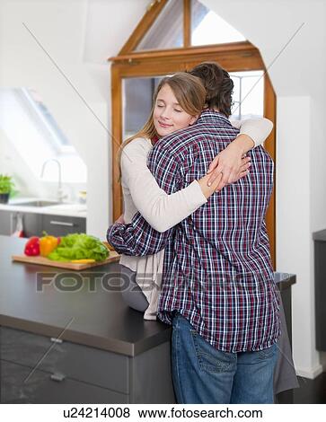 Couple hugging in kitchen View Large Photo Image Stock Photo - Couple hugging in kitchen. Fotosearch