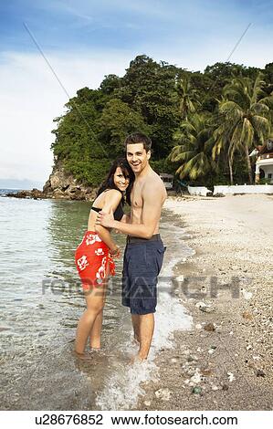 Stock Image - Couple hugging on tropical beach. Fotosearch