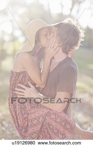 Couple kissing in field View Large Photo Image Stock Image - Couple kissing in field. Fotosearch
