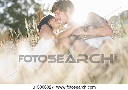 Couple kissing in wheatfield View Large Photo Image Stock Photo - Couple kissing in wheatfield. Fotosearch