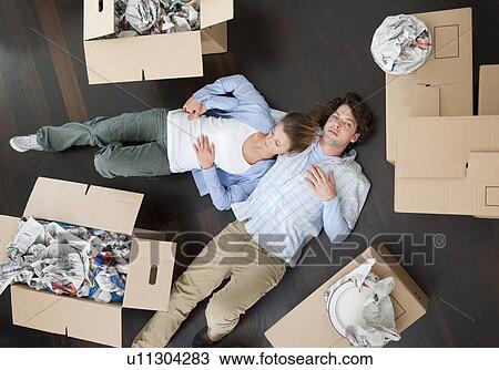 Stock Image - Couple laying together on floor. Fotosearch