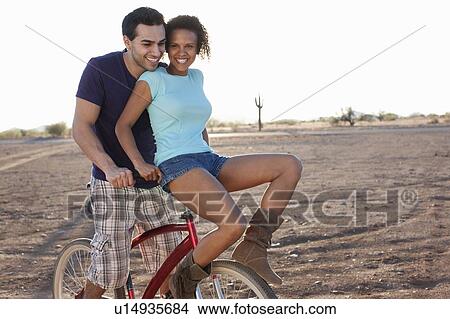 Couple on bicycle in desert landscape View Large Photo Image Picture - Couple on bicycle in desert landscape. Fotosearch