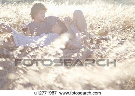 Couple picnicking in wheatfield View Large Photo Image Stock Photo - Couple picnicking in wheatfield. Fotosearch