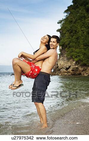Couple playing on tropical beach View Large Photo Image Stock Image - Couple playing on tropical beach. Fotosearch