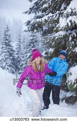 Couple playing together in snow View Large Photo Image Stock Image - Couple playing together in snow. Fotosearch