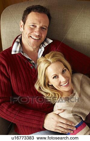 Couple relaxing on sofa together View Large Photo Image Stock Image - Couple relaxing on sofa together. Fotosearch