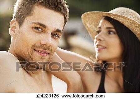 Couple relaxing together on beach View Large Photo Image Stock Photograph - Couple relaxing together on beach. Fotosearch