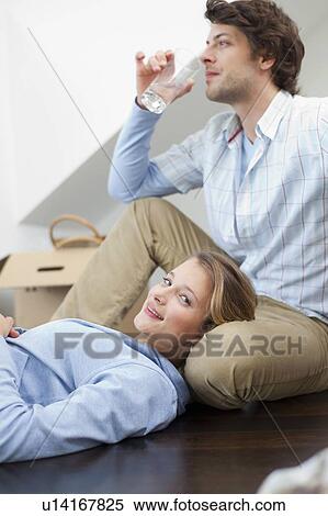 Couple relaxing together on floor View Large Photo Image Stock Photography - Couple relaxing together on floor. Fotosearch