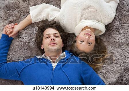Couple relaxing together on rug View Large Photo Image Picture - Couple relaxing together on rug. Fotosearch