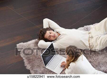 Couple relaxing together on rug View Large Photo Image Stock Image - Couple relaxing together on rug. Fotosearch