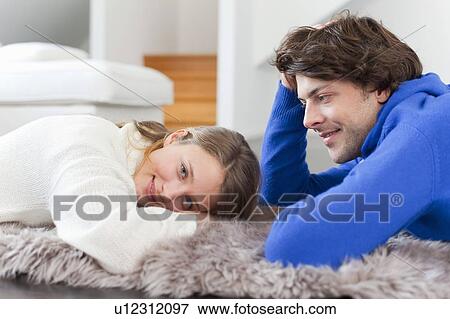 Stock Photo - Couple relaxing together on rug. Fotosearch