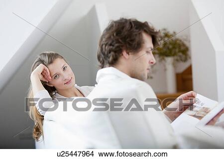 Picture - Couple relaxing together on sofa. Fotosearch