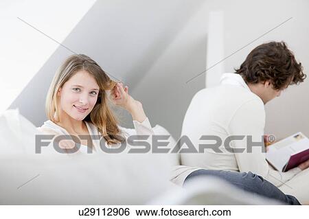 Stock Photograph - Couple relaxing together on sofa. Fotosearch