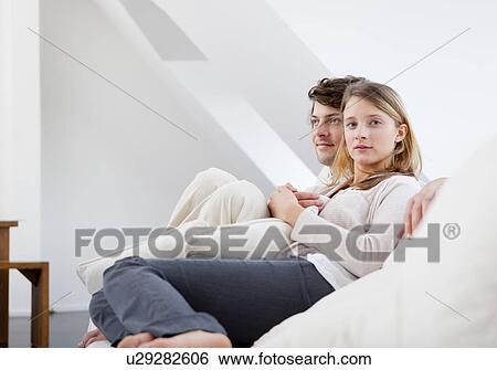 Stock Photograph - Couple relaxing together on sofa. Fotosearch