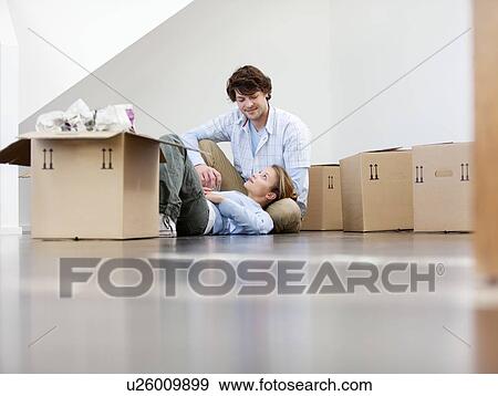 Stock Photo - Couple sitting with cardboard boxes. Fotosearch